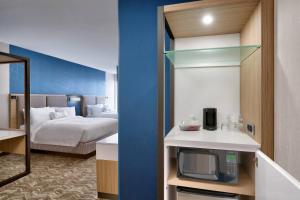 a hotel room with a bed and a tv in a room at Springhill Suites by Marriott Colorado Springs North/Air Force Academy in Colorado Springs