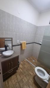 a bathroom with a toilet and a sink at Casa Barrio del Lago in Garupá