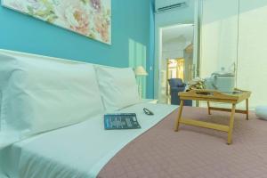 a bedroom with a bed with a table and a mirror at Cocoscape Seaside Suite, With Sea View in Kalamaki Heraklion