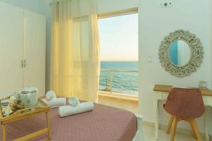 a bedroom with a bed with a view of the ocean at Cocoscape Seaside Suite, With Sea View in Kalamaki Heraklion