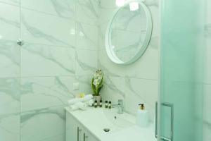 a white bathroom with a sink and a mirror at Cocoscape Seaside Suite, With Sea View in Kalamaki Heraklion +31 photos