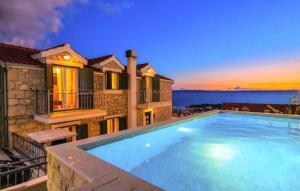 a villa with a swimming pool at dusk at Villa Elizabeta Makarska by Villas Guide in Makar