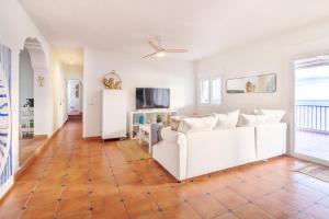 a living room with a white couch and a tv at Casa Mariposa in San José