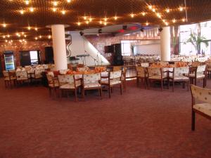 um salão de banquetes com mesas, cadeiras e luzes em Hotel Lovech em Lovech