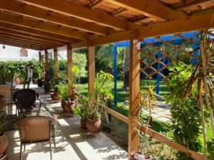 un patio con macetas y pérgola de madera en Giannis Private Villa, With Garden, en Kalamaki