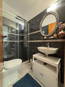 a bathroom with a toilet and a sink and a mirror at Iliaxtida Seaside Apartment in Kalamaki Heraklion