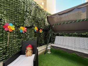 a stuffed teddy bear sitting on a bed next to a wall at Iliaxtida Seaside Apartment in Kalamaki Heraklion