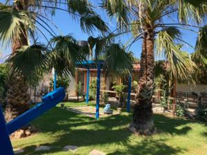 un parque infantil con palmeras y un tobogán azul en Giannis Private Villa, With Garden, en Kalamaki