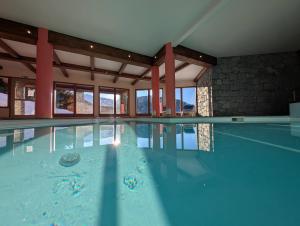 una piscina con agua azul en un edificio en Luxury Property Paradiski incl Swim Pool I Sauna I Hammam, en Peisey-Nancroix