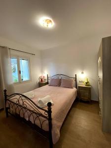 a bedroom with a bed and a window at Maria's House, With Garden in Kalamaki Heraklion