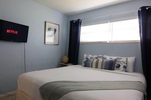 サラソタにあるVintage Vibes - Grill, Chill & Beach Thrillsの青い壁と窓のあるベッドのある寝室