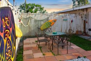 サラソタにあるVintage Vibes - Grill, Chill & Beach Thrillsのパティオ(テーブル、椅子、サーフボード付)