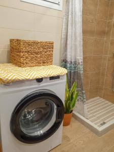 a washing machine in a bathroom with a shower at Maria's House, With Garden in Kalamaki Heraklion