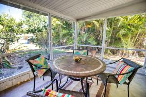 a screened in porch with a table and chairs at Stylish Retro Vibes Private Bbq & Beach Access in Sarasota +12 photos
