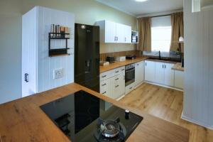 a kitchen with white cabinets and a black refrigerator at Sunset Lounge - Visit Langebaan in Langebaan