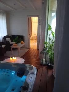 a bathroom with a tub in a living room at Le Charme au Fil de l'eau in Neslette