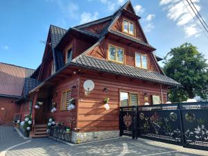 a large wooden house with a gambrel roof at Gościniec U Ani - pod wieżą widokową Sky Walk, nieopodal szlaków na Polane Rusinową , Gęsią Szyje, Polane Zgorzelisko , Tarasówke i Palenice in Male Ciche