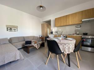 a kitchen and living room with a table and a couch at Orphanos Apartment in Kamilari