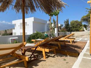 eine Reihe von Picknicktischen und Sonnenschirmen am Strand in der Unterkunft Poseidon House, With Seaview in Kalamaki + 11 Fotos