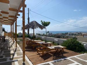 eine Gruppe von Tischen und Bänken auf einem Gebäude in der Unterkunft Poseidon House, With Seaview in Kalamaki