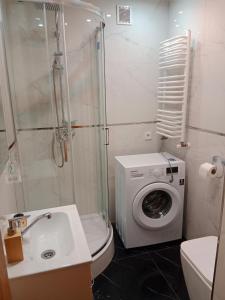 a bathroom with a washing machine and a washer at Przemyśl - centrum in Przemyśl