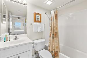 a white bathroom with a toilet and a sink at Pelican Isle 313 in Fort Walton Beach +11 photos