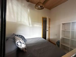 a bedroom with a bed with a pillow on it at Villa Victoria in Manantiales