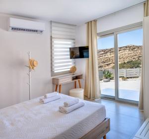 a bedroom with a bed and a view of the desert at Theasis Luxury Cave House, With Sea & Cave View in Matala