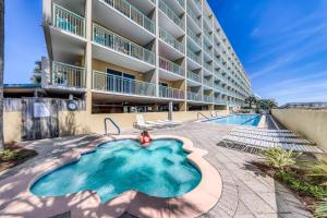 a swimming pool in front of a building at Pelican Isle 204 Gulf Clap in Fort Walton Beach