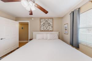 a bedroom with a bed and a ceiling fan at Pelican Isle 204 Gulf Clap in Fort Walton Beach +28 photos