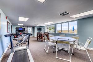 a living room with a table and chairs and a table and a tv at Pelican Isle 204 Gulf Clap in Fort Walton Beach