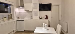 a white kitchen with a table and a sink at Lucky Lady in Spital am Pyhrn