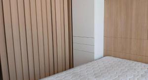 1 dormitorio con colchón blanco en una pared de madera en Armónico en Bs As, en Buenos Aires