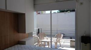 1 dormitorio con 1 cama y 2 sillas en el balcón en Armónico en Bs As, en Buenos Aires