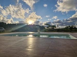 a pool of water with the sun in the sky at Flats Vila Bella in Marau