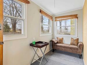 a living room with a couch and two windows at Swing Bridge Cottage on Lake Simcoe - Waterfront in Brechin