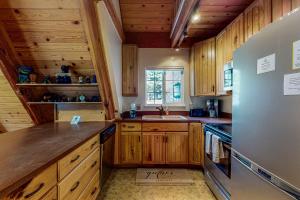 une cuisine avec des armoires en bois et un réfrigérateur en acier inoxydable dans l'établissement Everness Dawn Retreat*, à Mevers