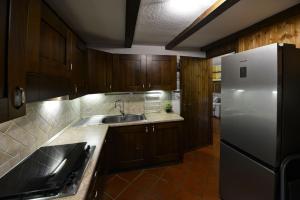 Una cocina con gabinetes de madera y un refrigerador blanco. en Maison EsterLina, en Villaret 12 fotos más