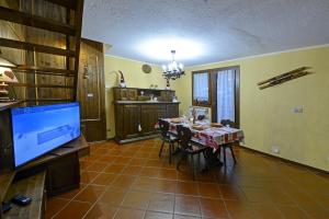 comedor con mesa y TV en una habitación en Maison EsterLina, en Villaret