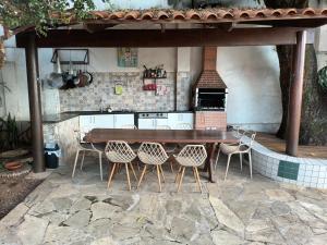an outdoor kitchen with a wooden table and chairs at Sobrado sustentavel e ecológico alugo 1o andar setor campinas in Goiânia