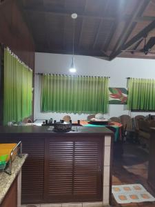 eine Küche mit grünen Vorhängen und einer Arbeitsplatte in der Unterkunft Casa para Réveillon na praia in São Sebastião
