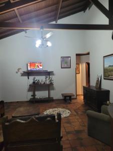 ein Wohnzimmer mit einer Couch und einem Deckenventilator in der Unterkunft Casa para Réveillon na praia in São Sebastião