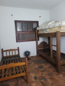 Zimmer mit 2 Etagenbetten und einem Stuhl in der Unterkunft Casa para Réveillon na praia in São Sebastião