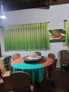 Zimmer mit einem Tisch und einem grünen Vorhang in der Unterkunft Casa para Réveillon na praia in São Sebastião + 9 Fotos
