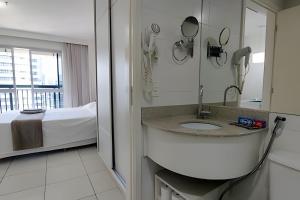 巴西利亚Vision, local nota 10! Academia, sauna e piscinas.的带水槽和床的浴室