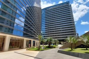 巴西利亚Vision, local nota 10! Academia, sauna e piscinas.的一座前面有棕榈树的高楼