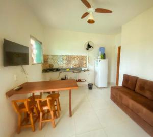 a kitchen and living room with a table and a couch at Flats Vila Bella in Marau