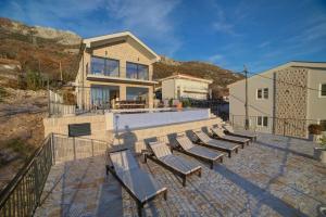 a group of benches sitting in front of a house at Villa Jelena with private pool - Lapcici in Budva