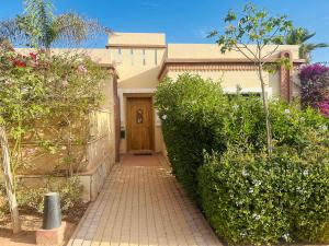a walkway leading to a house with a wooden door at Villa 228 Dyar Shemsi in Taroudant
