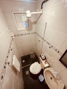 a small bathroom with a toilet and a sink at Pousada Canto de Geribá in Búzios